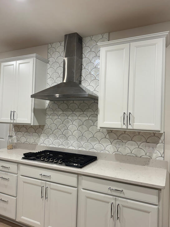 Kitchen backsplash with fan-shaped tile behind range hood Kitchen backsplash with fan-shaped tile behind range hood